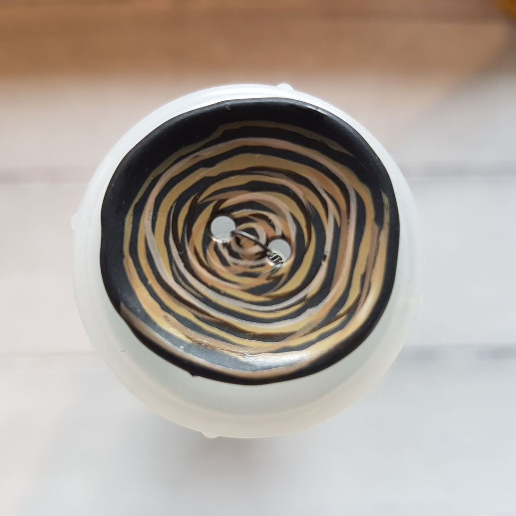 Knopf aus Kunststoff glänzend (2,8cm) rund mit Kringel in schwarz/beige